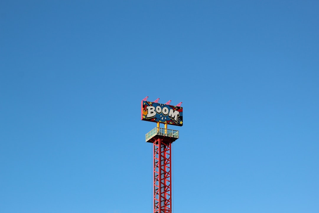 red tower with Boom sign under blue sky