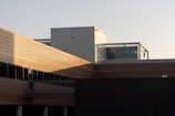 Modern exterior of a building featuring clean lines in dark gray and soft brown pastel tones.