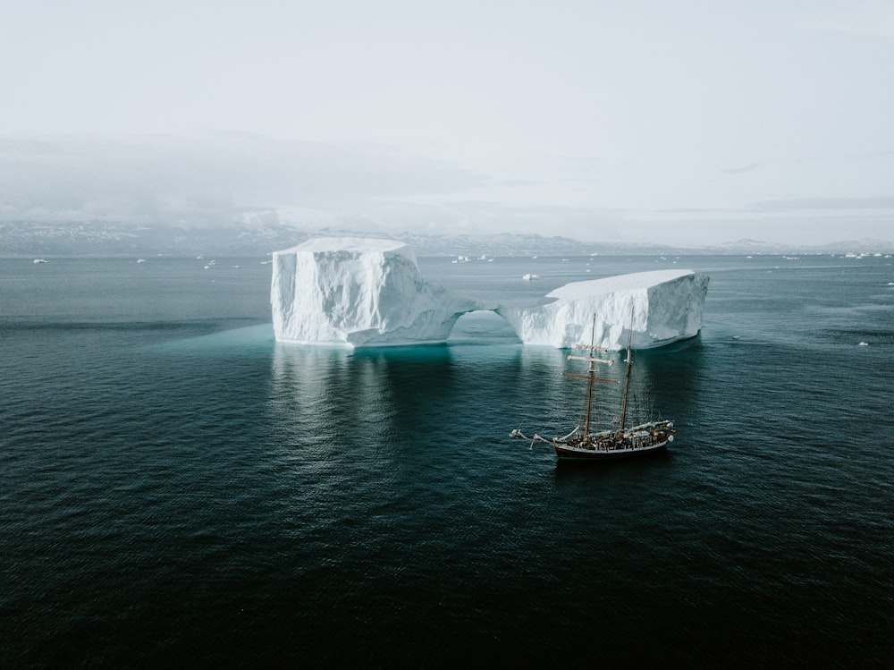 nave marrone e bianca vicino all'iceberg