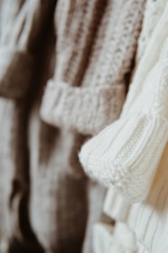 Close-up of knitted scarves and mittens in soft pastel colors.
