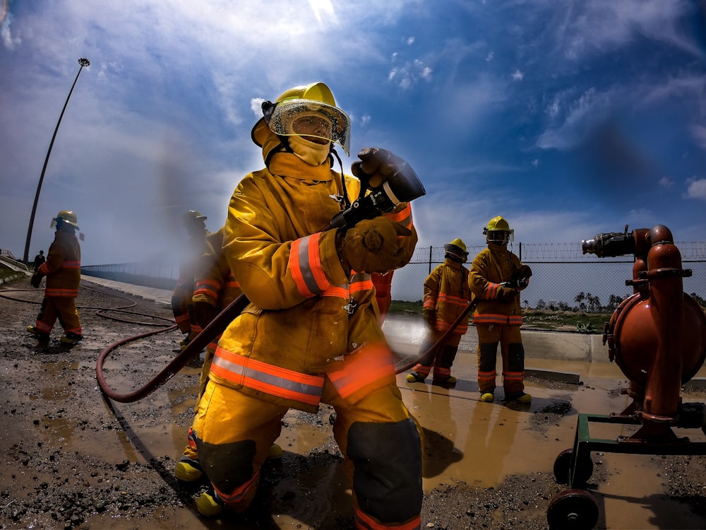 fireman holdng fire hose during daytime