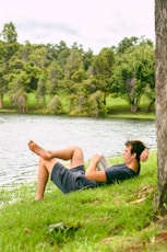 man on grass while reading book