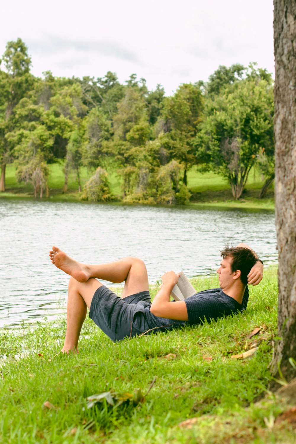 man on grass while reading book
