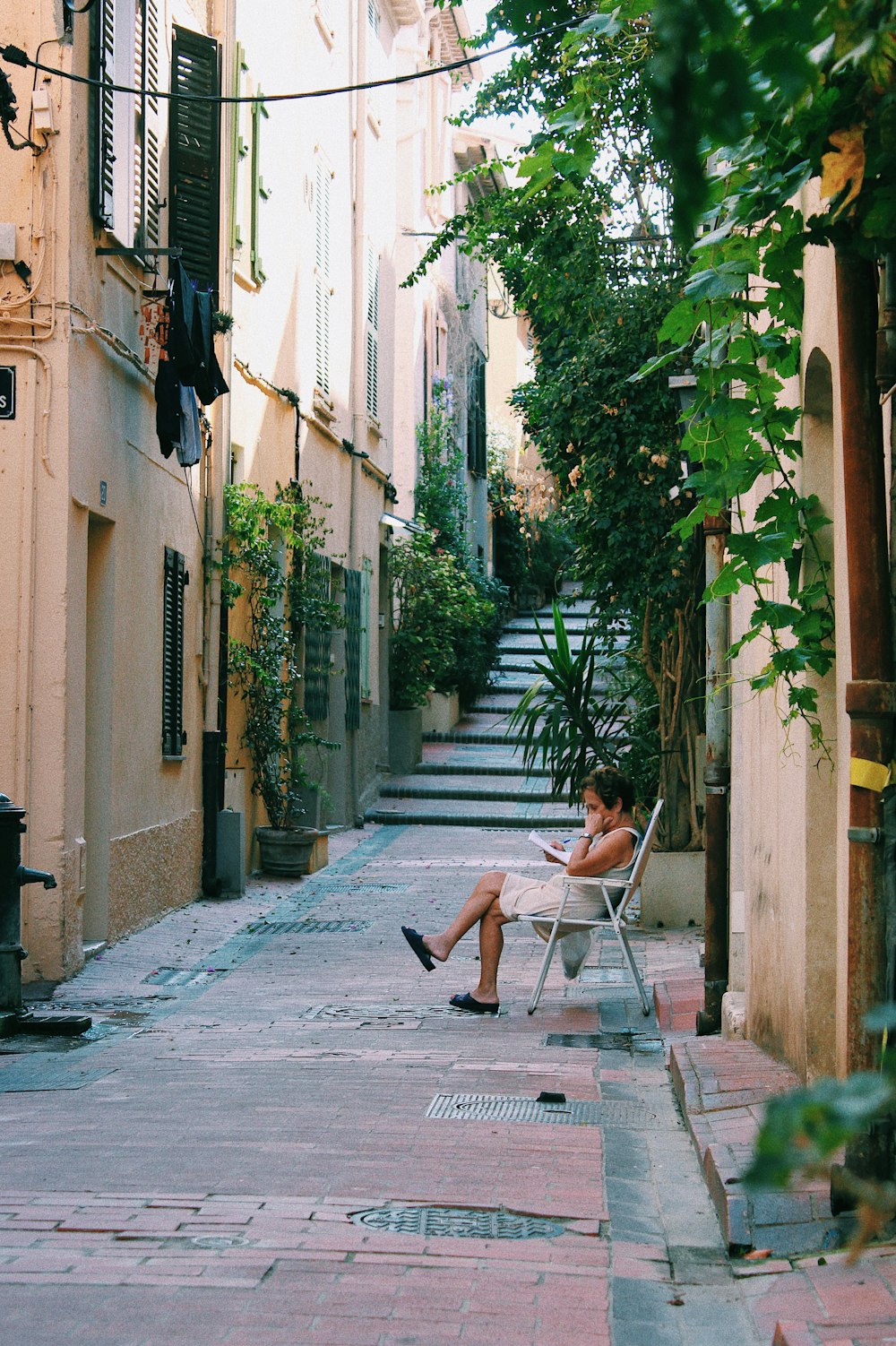 woman sitting on armchair reading book