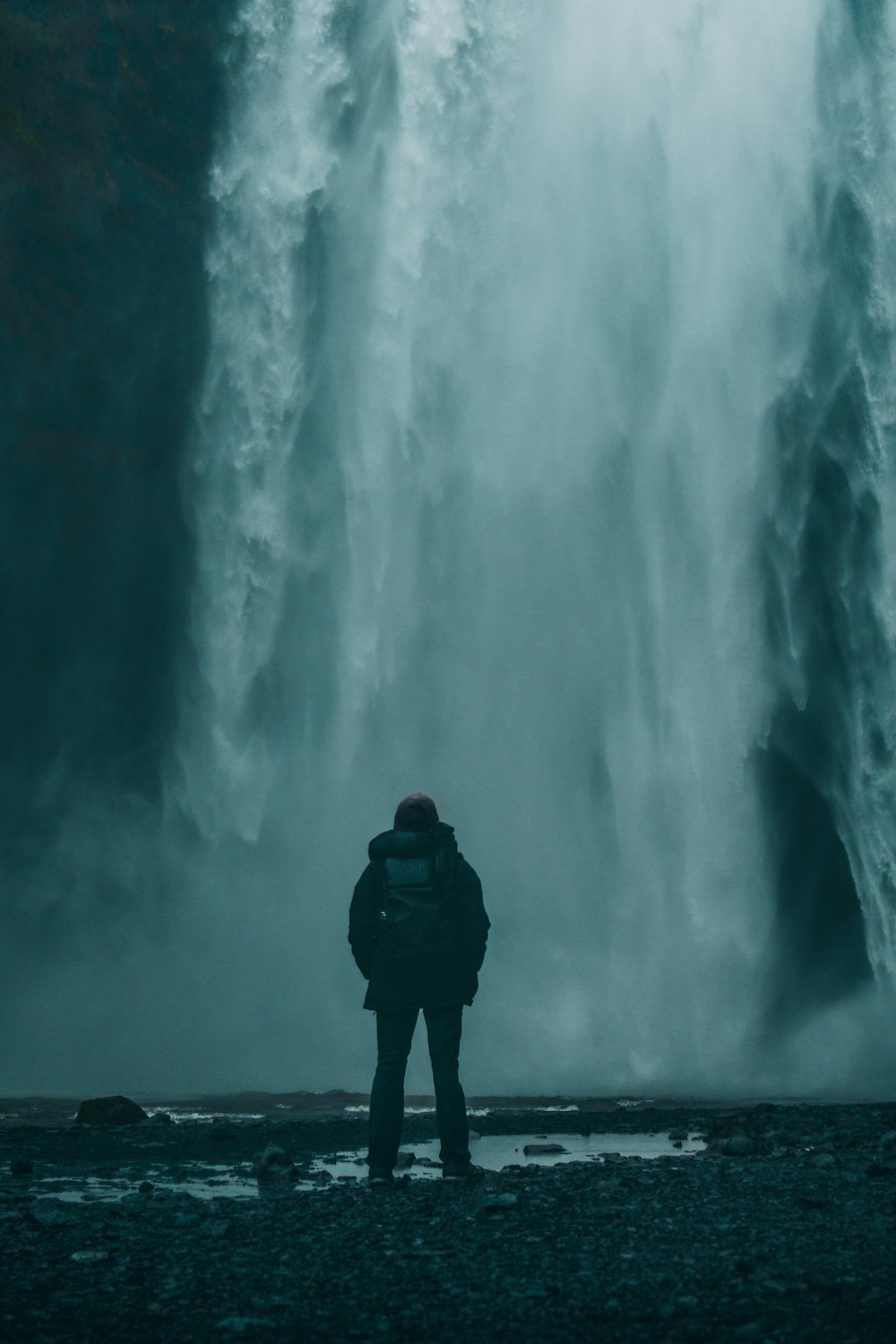 backpacker facing a waterfall