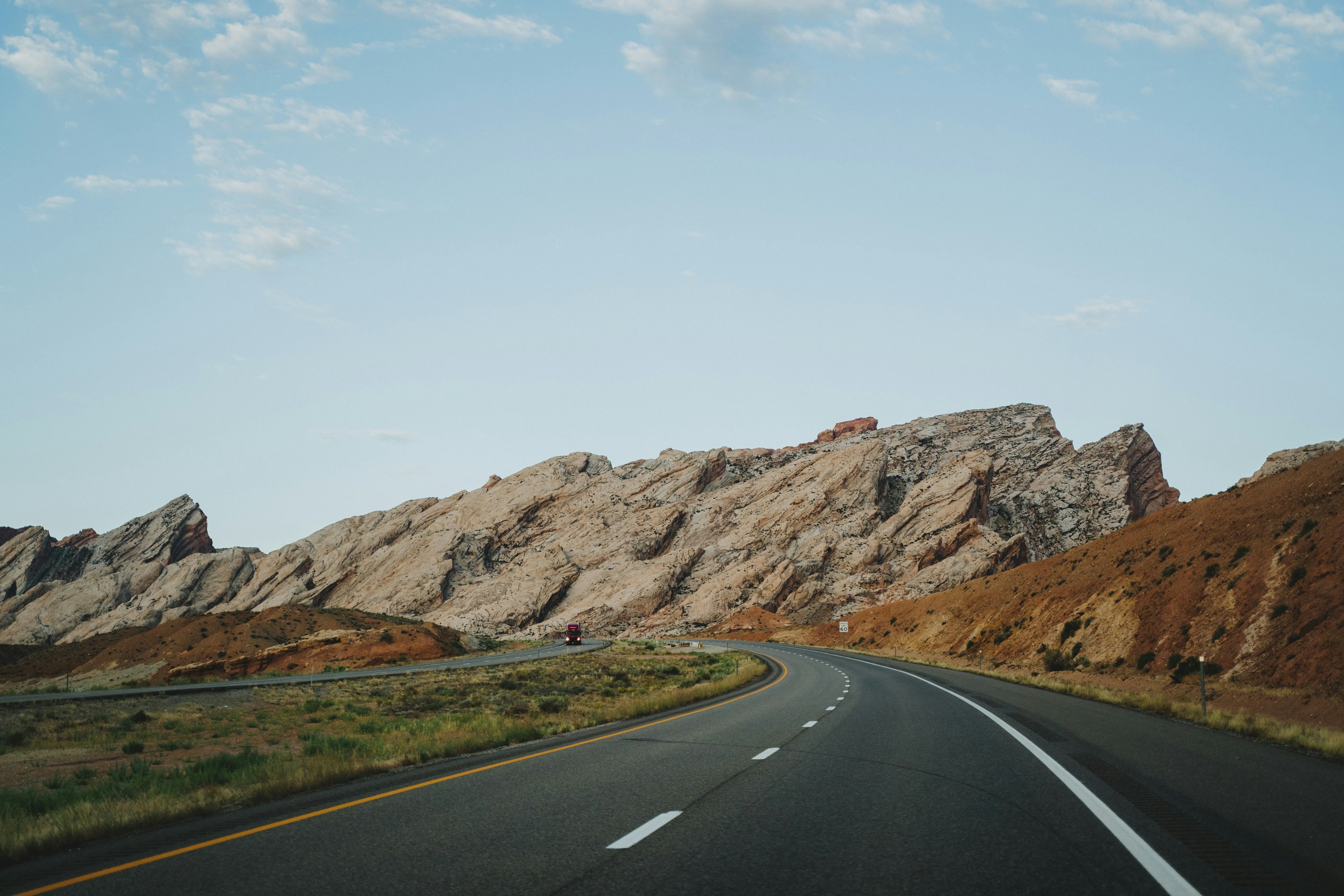 road beside grass and mountains during day