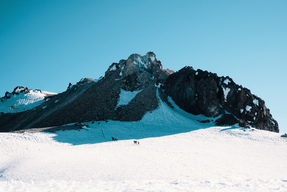 field and mountain covered with snow during daytime