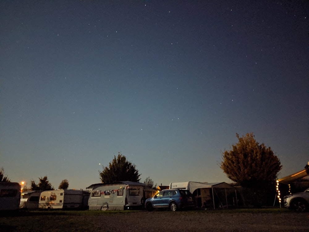 a group of rvs parked in a field at night