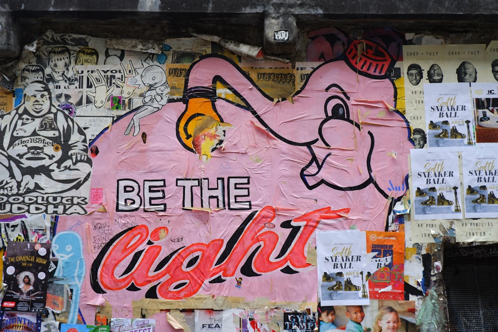 a wall covered in posters and stickers with the words be the light