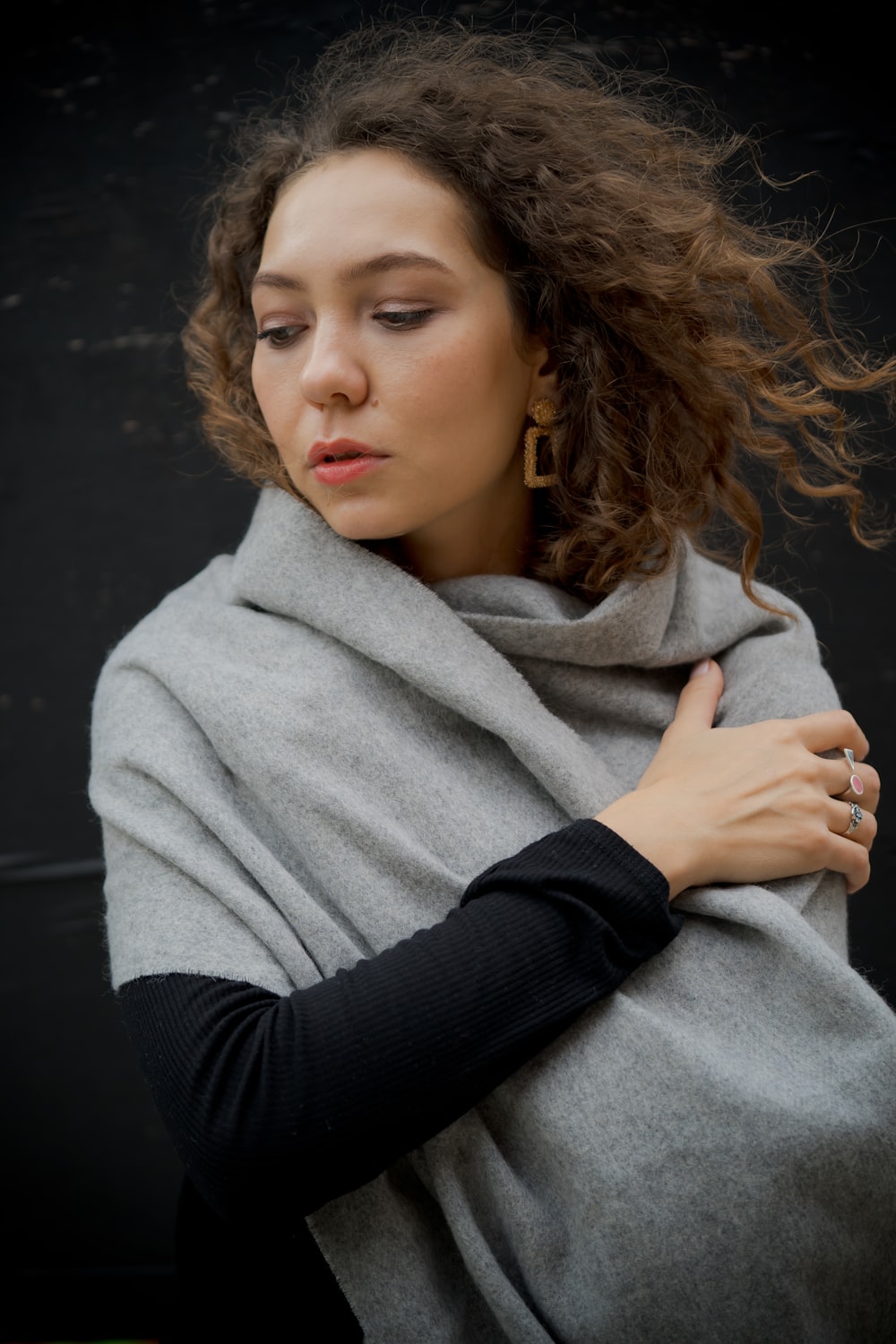 a woman wrapped in a blanket looking down