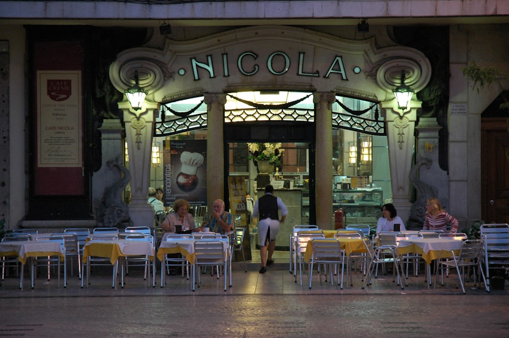 people sitting on chair near green and brown store during daytime