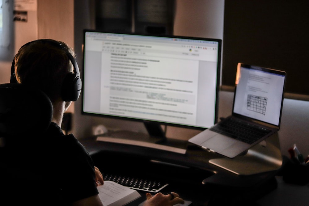Hombre usando computadora portátil y auriculares