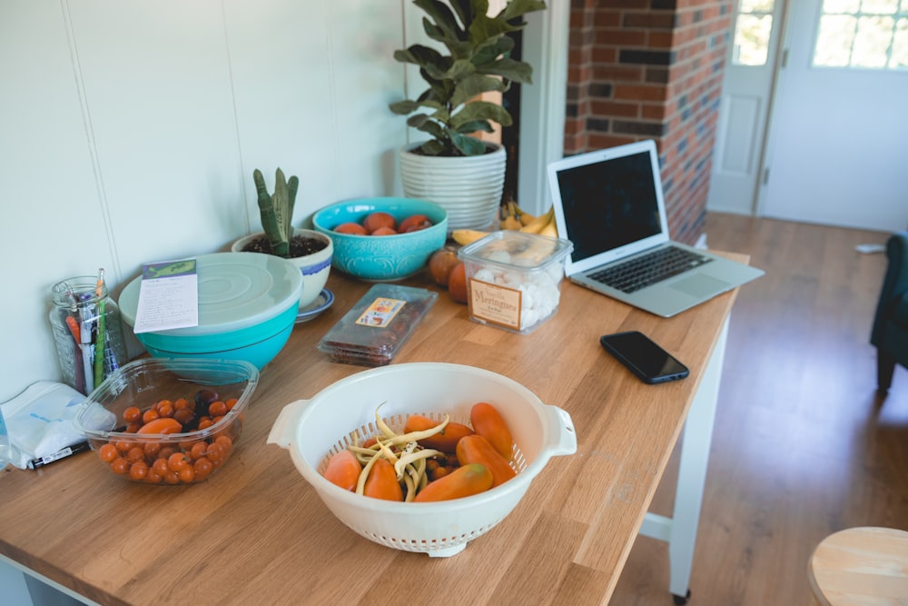 orange fruits in white basket on top of brown table