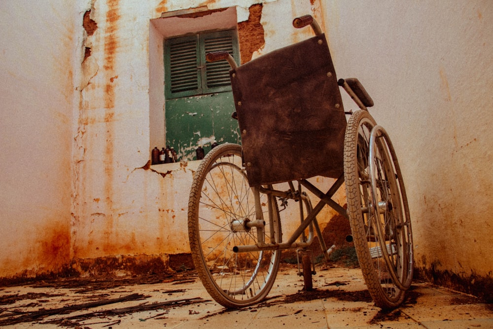 gray wheel chair beside wall