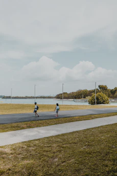 Two boys smiling together, backpacks on, ready for an adventure in a sunny park.