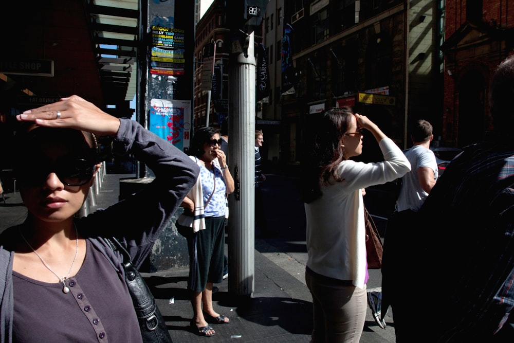 woman wearing white long-sleeved shirt walking on street