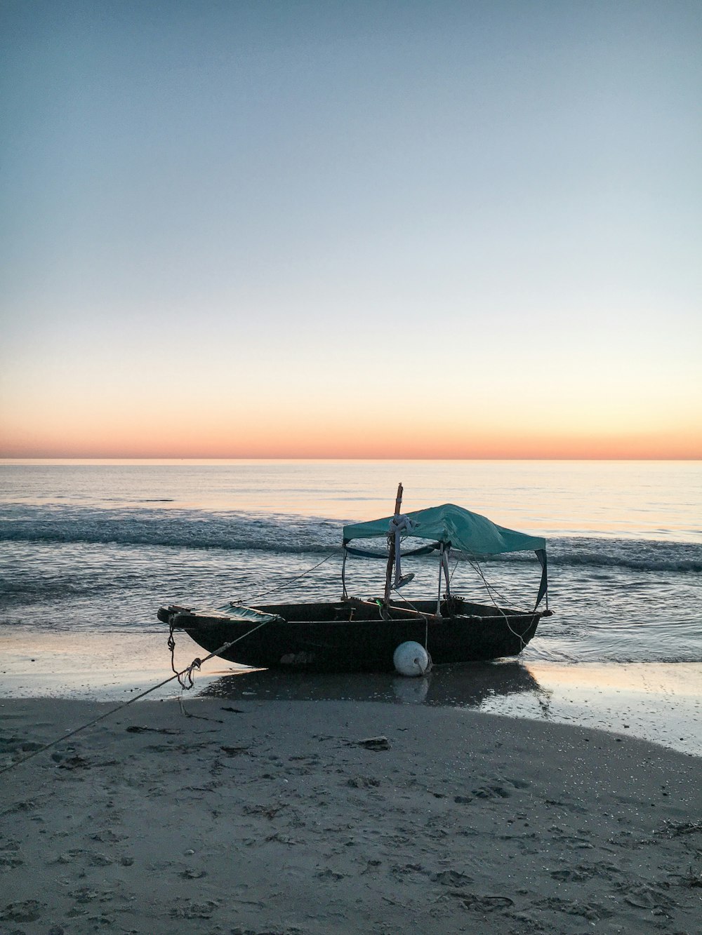 Un bateau assis au sommet d’une plage de sable
