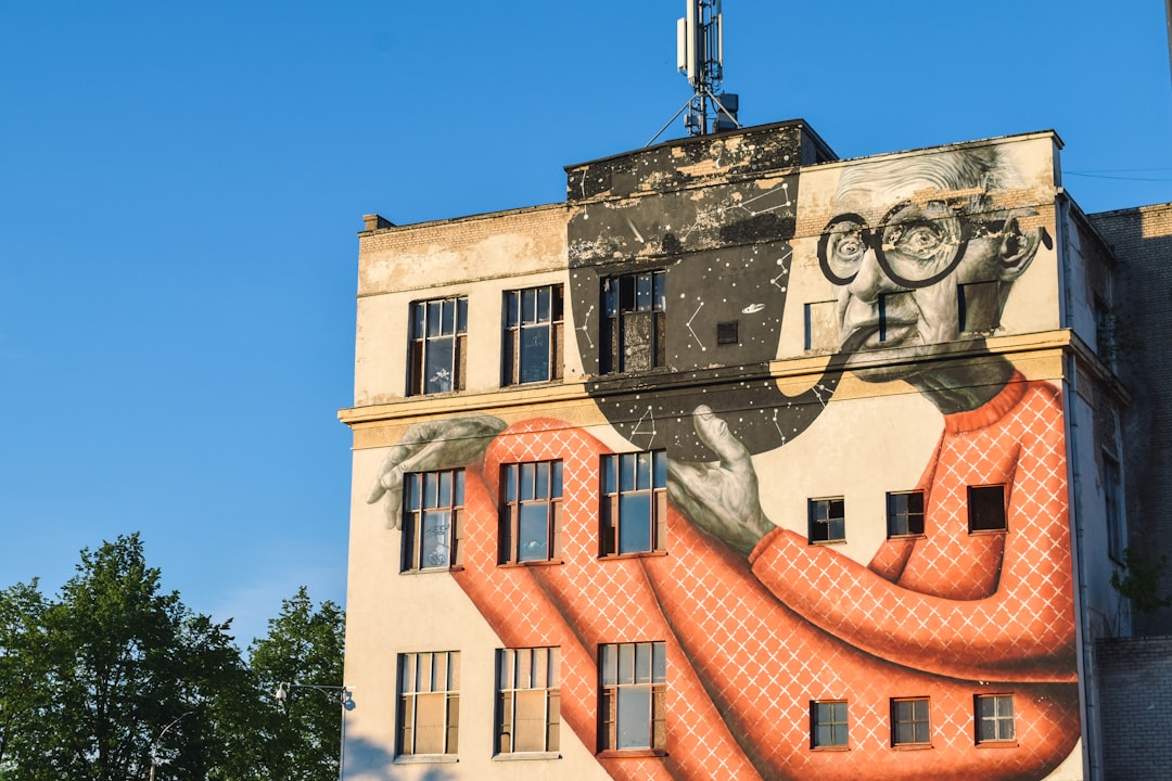 beige building with man smoking painting