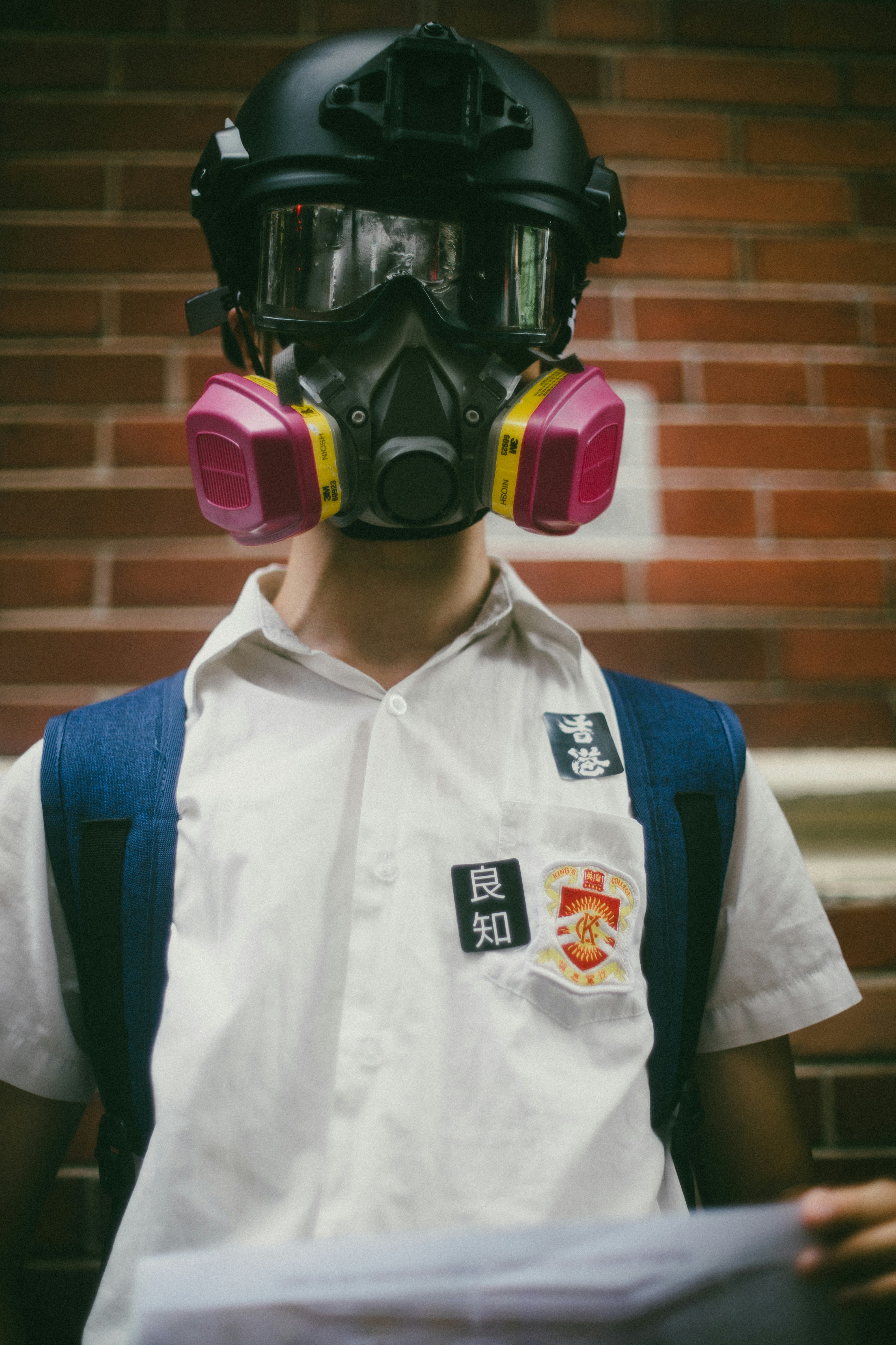 After a summer of demonstrating in the streets, high school students in Hong Kong starting the new school year on Monday arrived to class wearing gas masks and joined hands to form human chains. Stickers on the shirt read 'Hong Kong' and 'conscience' demanding a call for universal suffrage in Hong Kong and an independent inquiry into accusations of police brutality - September 2019