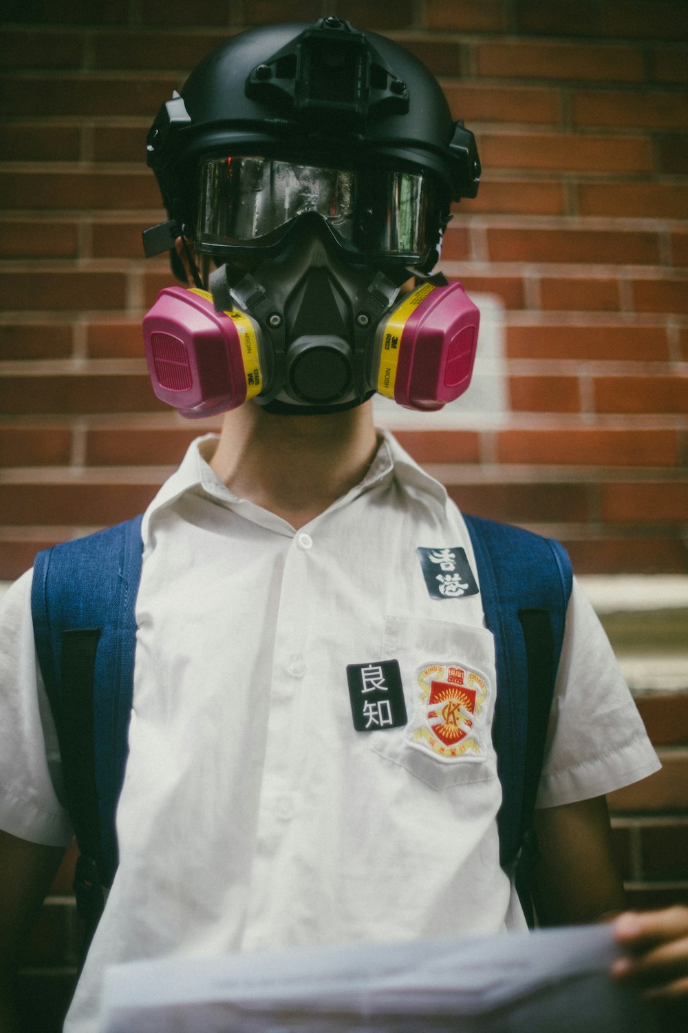 garçon portant un masque à gaz noir en position debout