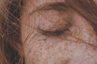 Close-up of a sun-kissed cheek with delicate freckles tattooed for a natural look.