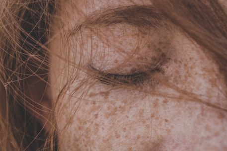 Close-up of a sun-kissed cheek with delicate freckles tattooed for a natural look.
