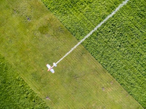 an aerial view of a field with a jet flying over it