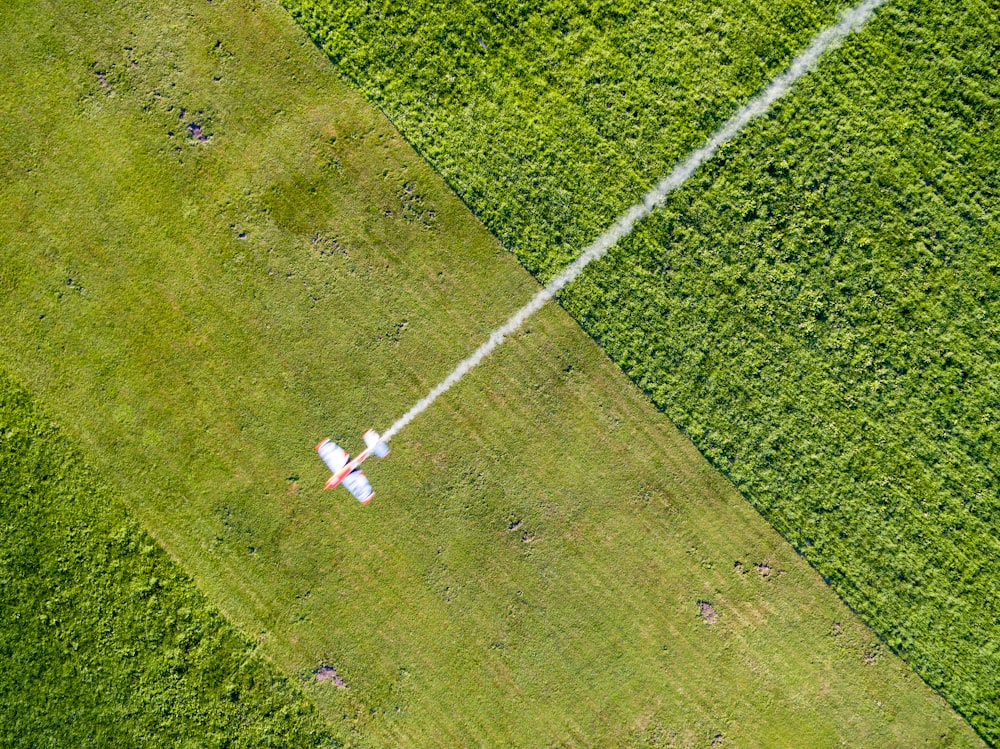 una vista aérea de un campo con un jet volando sobre él