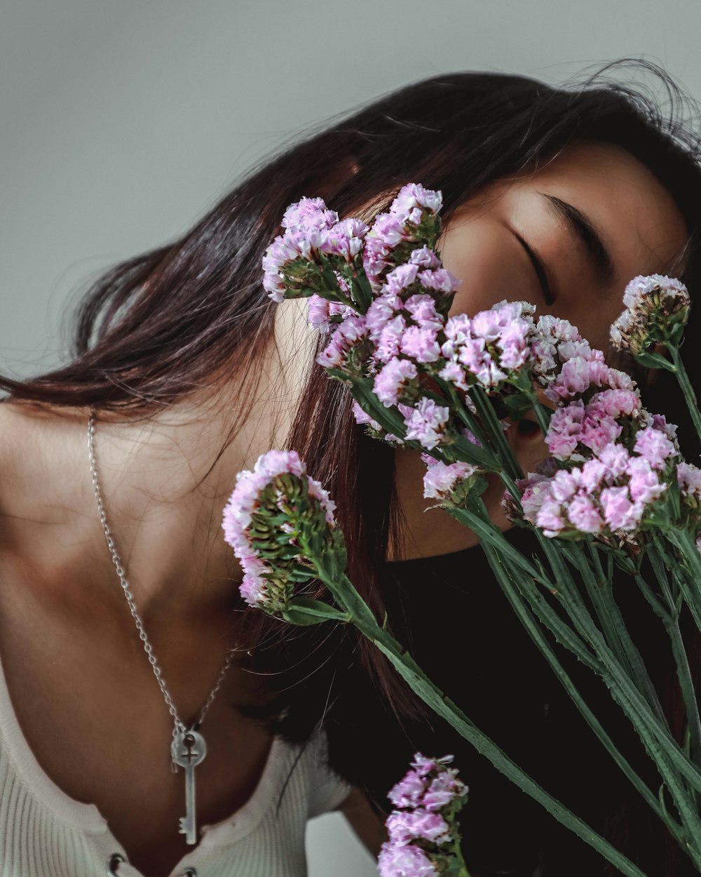 woman smelling purple petaled flower