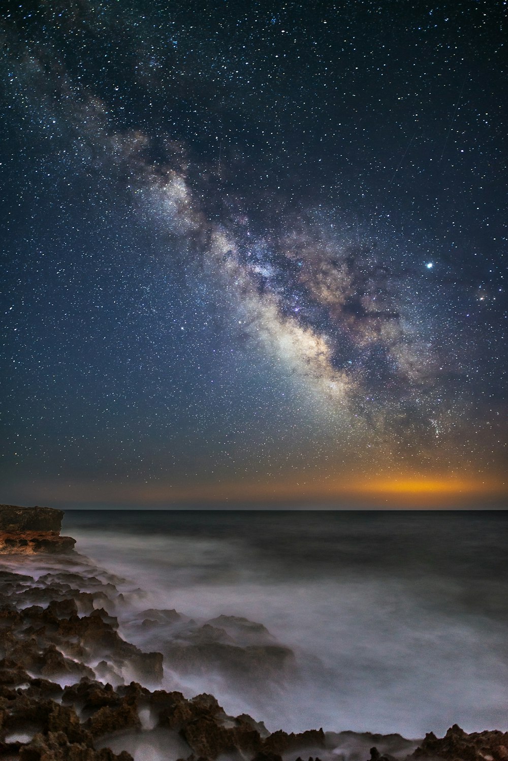 星空の夜の岩だらけの海岸