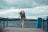 woman standing on dock and bending her body during daytime