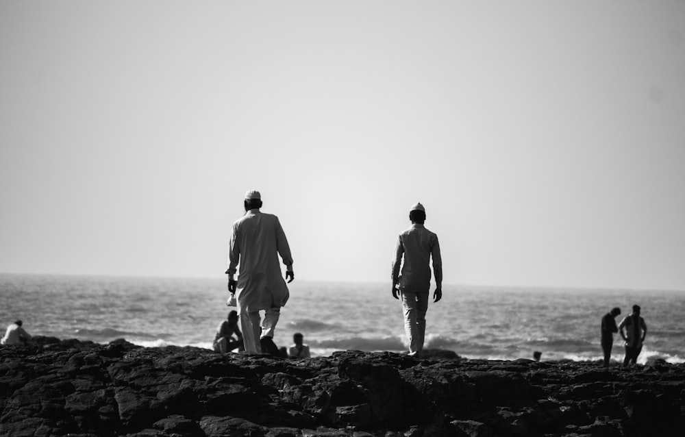 two person standing on rock