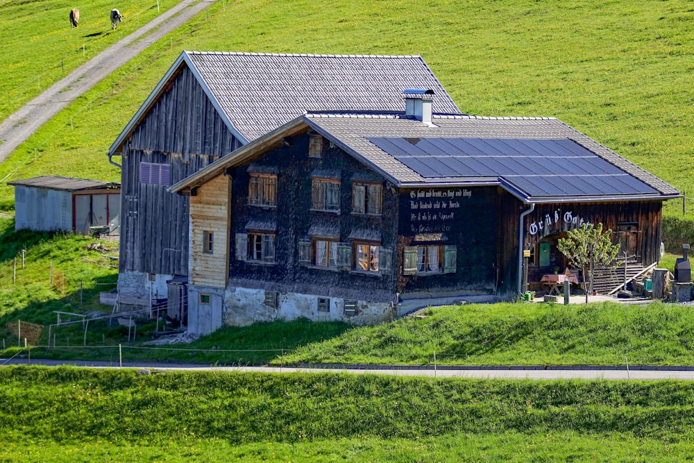 Casa de madera gris y negra en medio del campo
