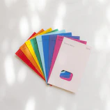 A detailed shot of color swatches fanned out on a wooden table beside paintbrushes.