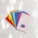 A collection of colorful paint swatches is fanned out on a white surface. Each swatch displays a distinct color and is labeled with a color name and code. The swatches include bright shades of red, orange, yellow, green, blue, purple, pink, and a neutral shade. The lighting creates soft shadows and highlights on the surface.