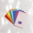 A collection of colorful paint swatches is fanned out on a white surface. Each swatch displays a distinct color and is labeled with a color name and code. The swatches include bright shades of red, orange, yellow, green, blue, purple, pink, and a neutral shade. The lighting creates soft shadows and highlights on the surface.