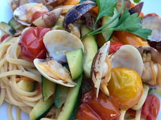 Close-up of a steaming plate of spaghetti with tomato sauce and fresh herbs.