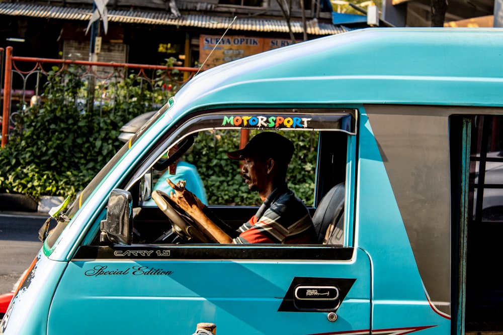 man riding teal enclose van