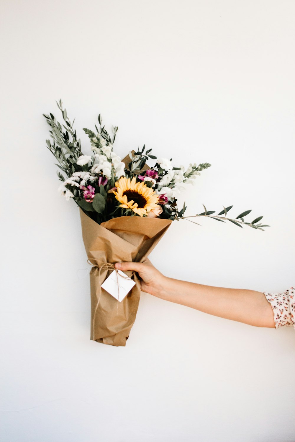 personne tenant un bouquet de fleurs