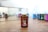 A bottle of essential oil labeled 'Thieves' from Young Living is placed on a wooden surface. The bottle has a white cap and a brown body. In the background, several other bottles of essential oil in various colors are slightly out of focus, reflecting on a mirror.