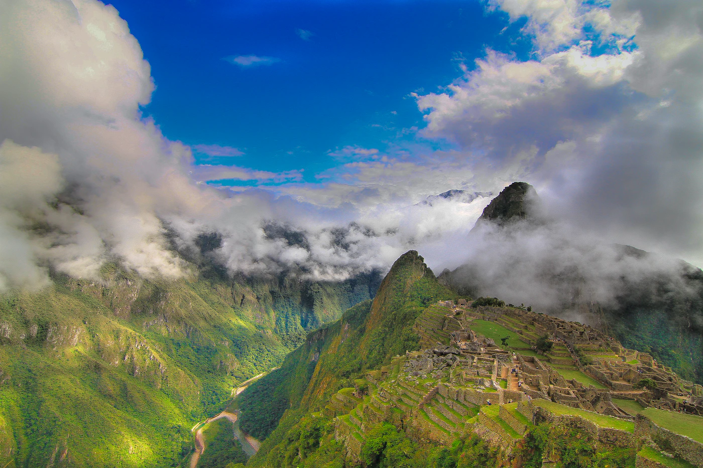 Aerial view of the ancient Inca citadel of Machu Picchu Peru surrounded by the lush green cloud-forest Andean mountains with the ruins set against the dramatic mountain landscape