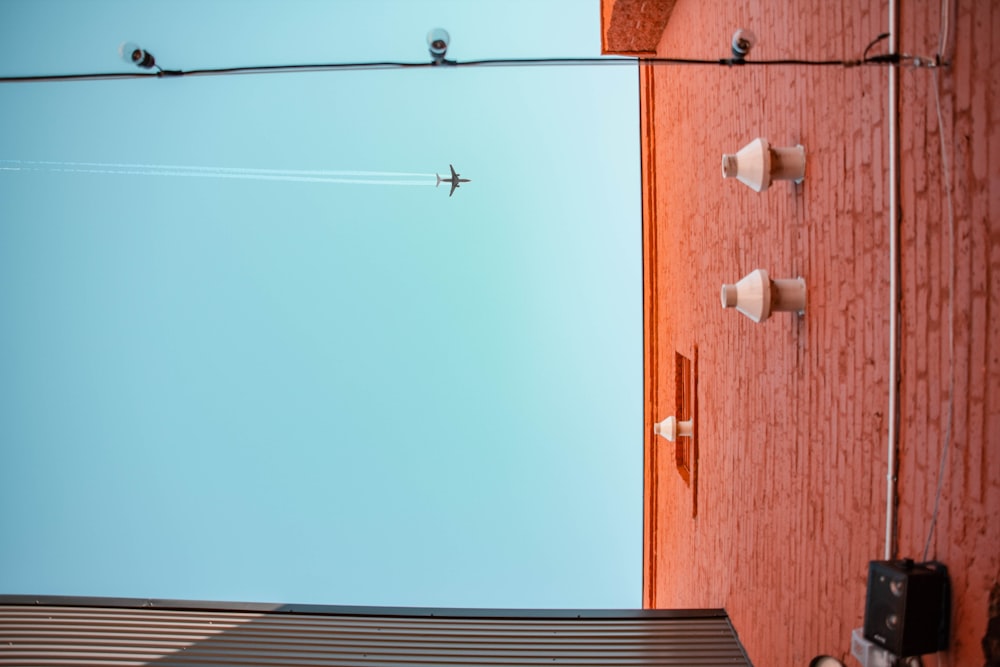 an airplane is flying in the sky over a building