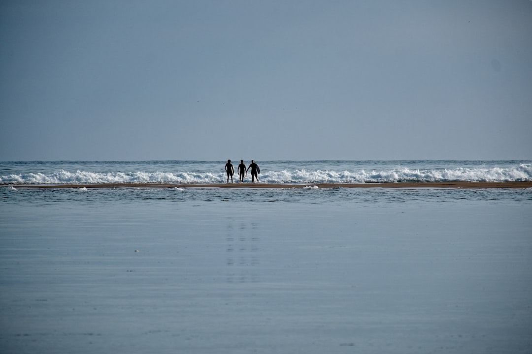 photography of three people running on beach