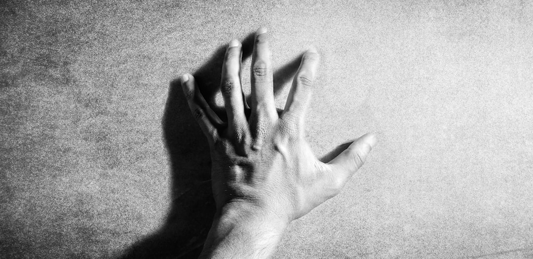 left human hand in grayscale photography
