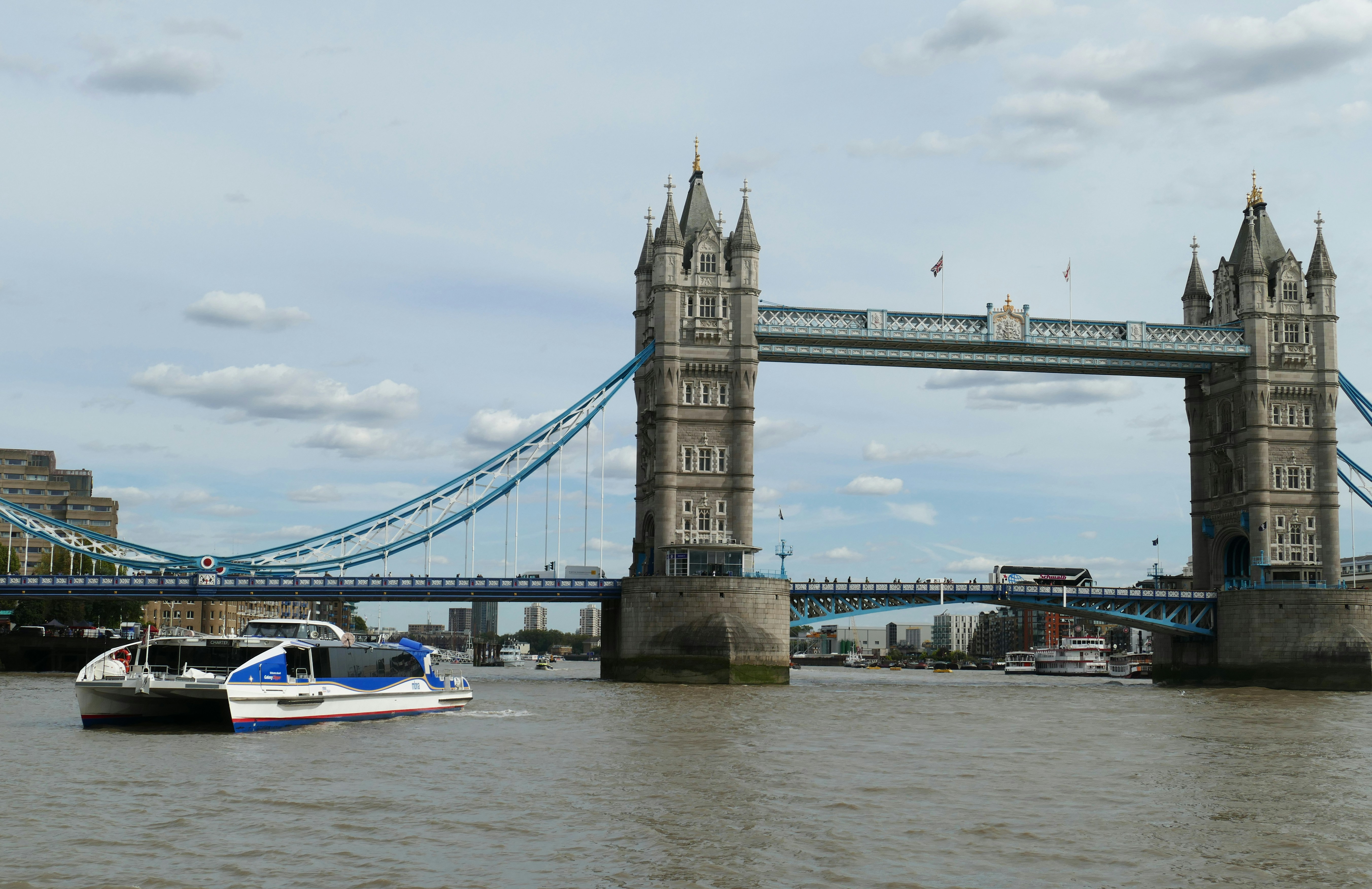 white motorboat near to bridge, Thames Clipper in front of Tower Bridge.