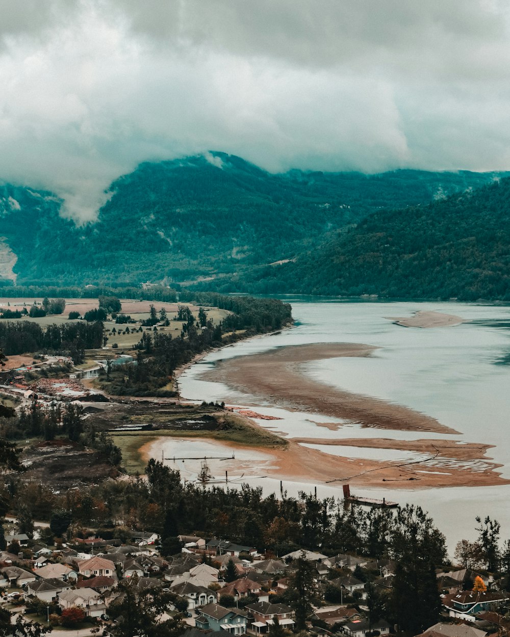 high-angle photography of brown body of water under nimbus clouds