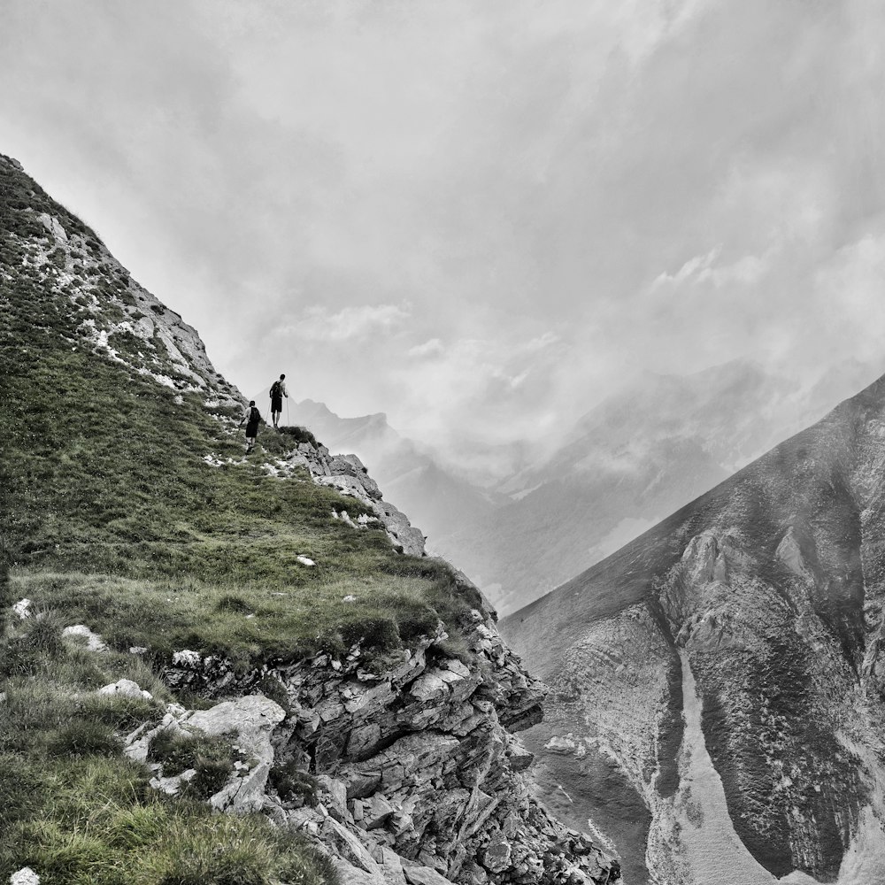 Persona de pie en el acantilado bajo el cielo nublado durante el día