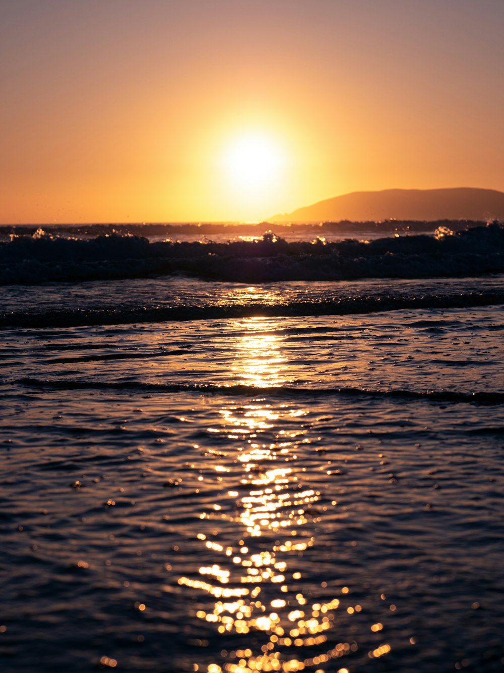 waves crashing on shore during golden hour