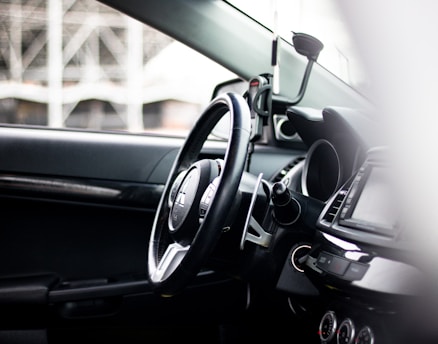 Close-up of a sleek car dashboard with illuminated controls and a smartphone mount.