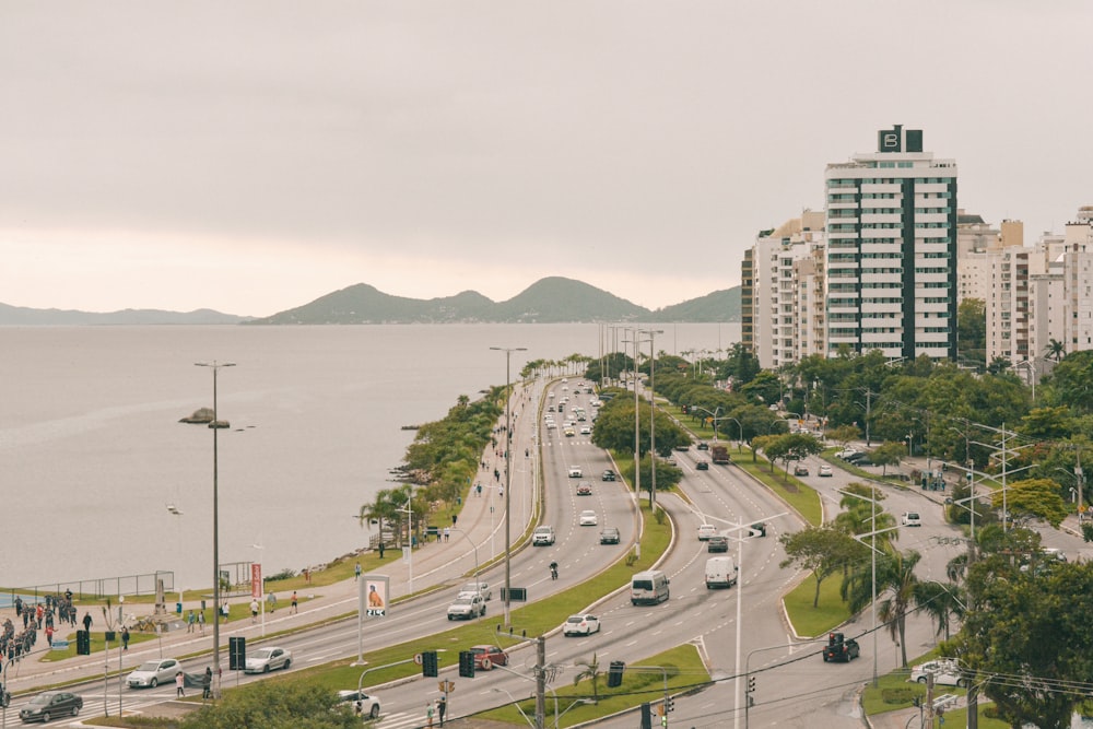 fotografia de alto ângulo de carros na estrada perto da praia